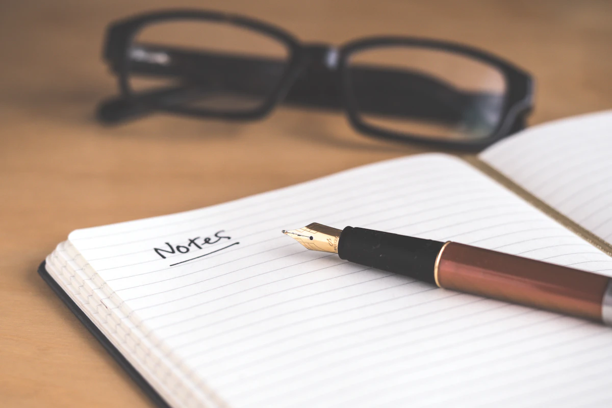 Open paper notebook with a warm cup beside it